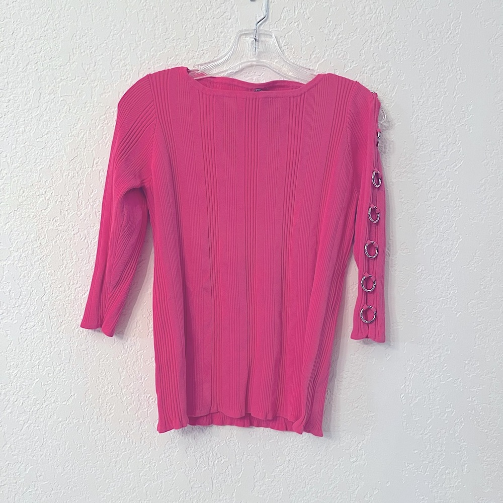 Pink Sweater with metal arm cutouts.